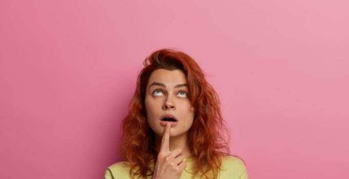 mujer de pelo rojo muy pensativa