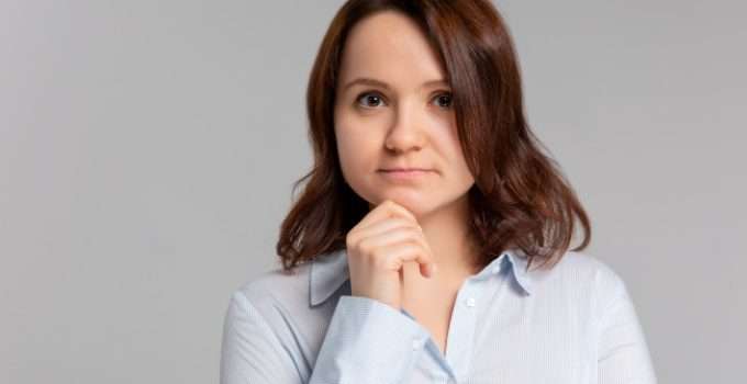 mujer sosteniendo su mentón con duda