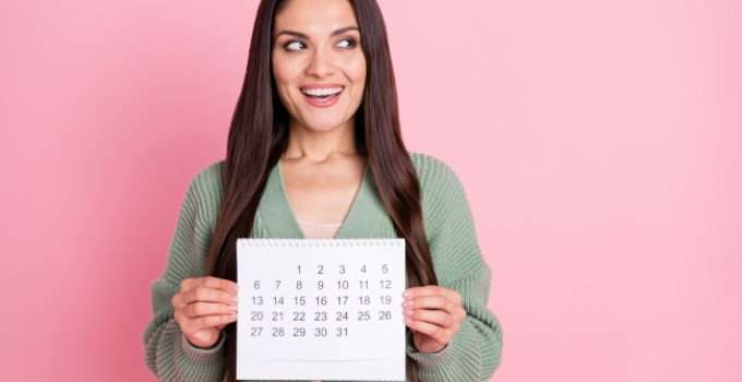 mujer sostiene un calendario porque cuenta cuántos días dura