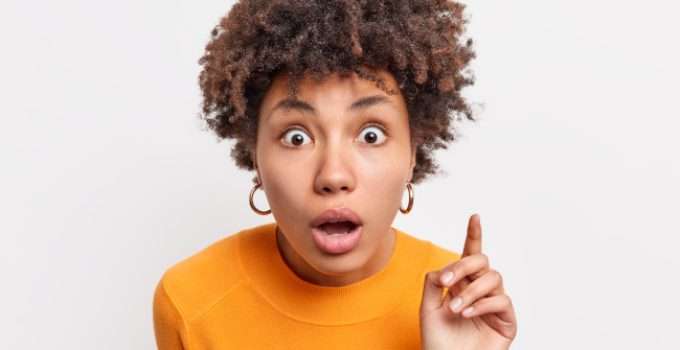 mujer de pelo rizado escucha atenta efectos secundarios de la keratina