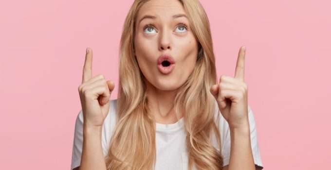 mujer señala con sus dedos hacia arriba