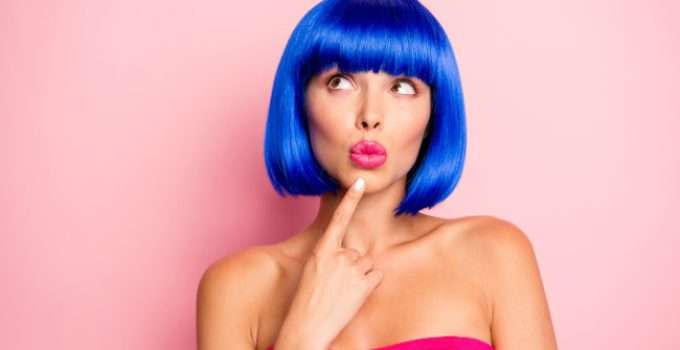 mujer con pelo azul piensa para qué sirve el shampoo azul