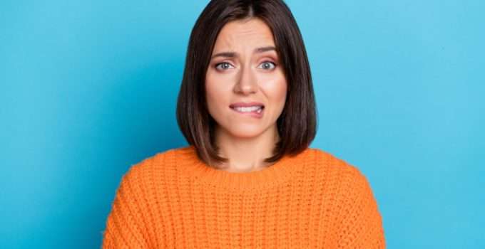 mujer se muerde el labio pensando en el tinte 7.1 en pelo oscuro