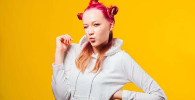 Una mujer joven con mucha actitud lleva el cabello rojo fantasía