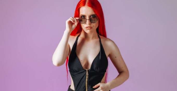 Una chica con gafas y pelo teñido de rojo cereza