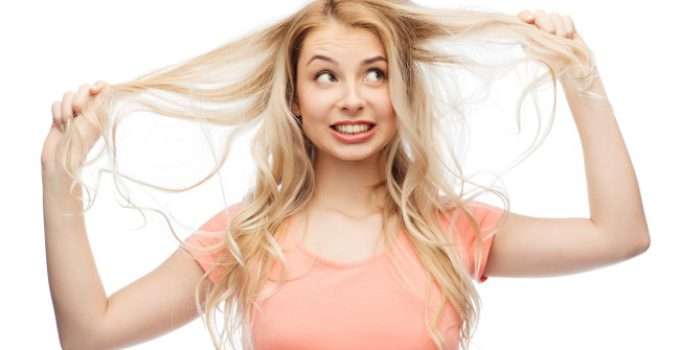 mujer rubia agarra su pelo amarillo