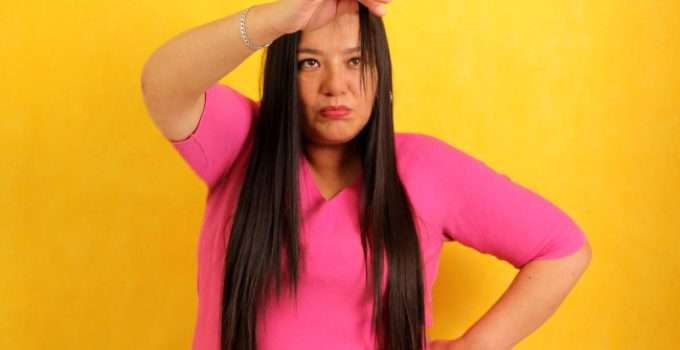 mujer de pelo oscuro mira su cabello pensando en decoloraciones