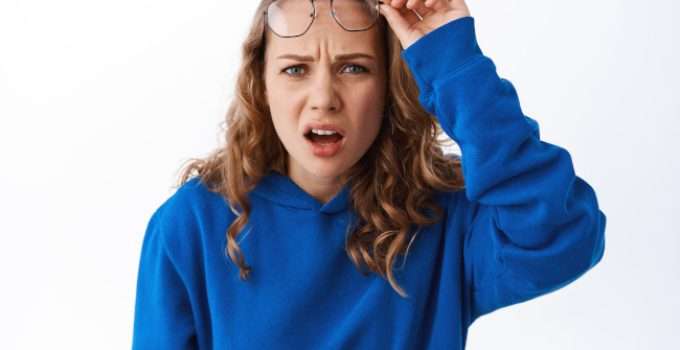 mujer levanta gafas mientras piensa en mezclar tinte chocolate