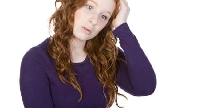 mujer de pelo cobrizo triste porque quiere pasar a pelo castaño