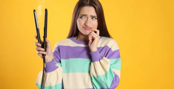 mujer con pelo con nanoplastia y planchita en la manoan