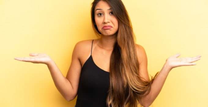 Una jovencita con palmas hacia arriba en señal de desconcierto acerca de lo que se necesita para decolorar el pelo