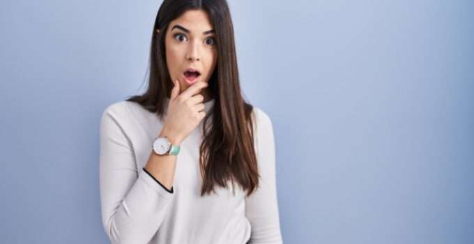 Una jovencita con expresión de desconcierto sobre cuánto tiempo debe dejar el decolorante para llegar a blanco