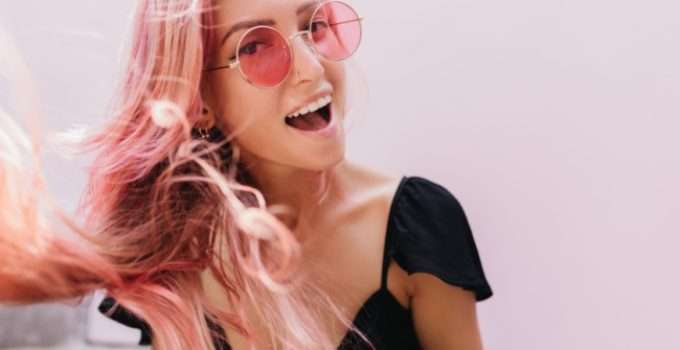 Una joven feliz con su pelo rosa fantasía