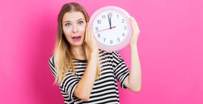 mujer con reloj en la mano piensa en matizante cenizo