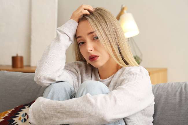 Una muchacha se agarra la cabeza porque se dejó la keratina toda la noche y teme perder el cabello