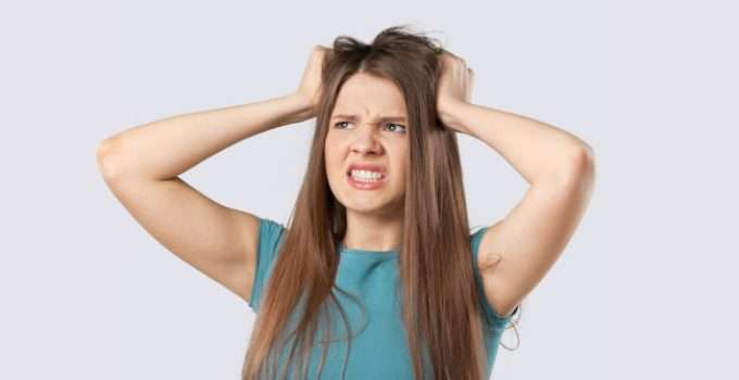 Jovencita se rasca la cabeza por alergia a la henna