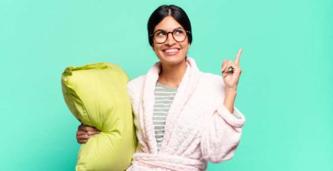 Muchacha con una almohada y ropa de dormir se pregunta si puede dejarse la keratina toda la noche