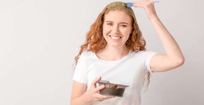 Una jovencita se aplica henna para teñir sus canas