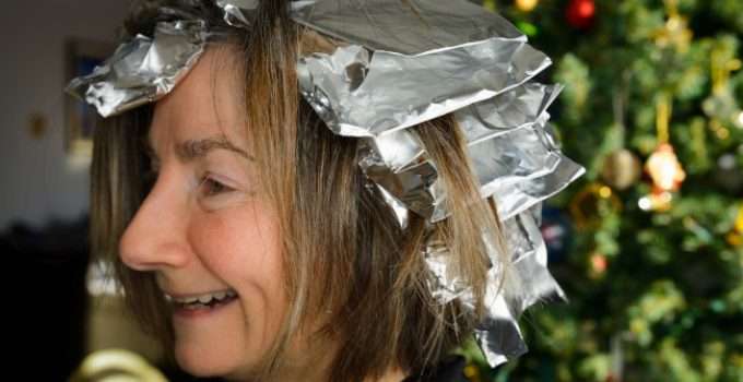 Una mujer a la que se le está decolorando el cabello con decolorante y papel aluminio