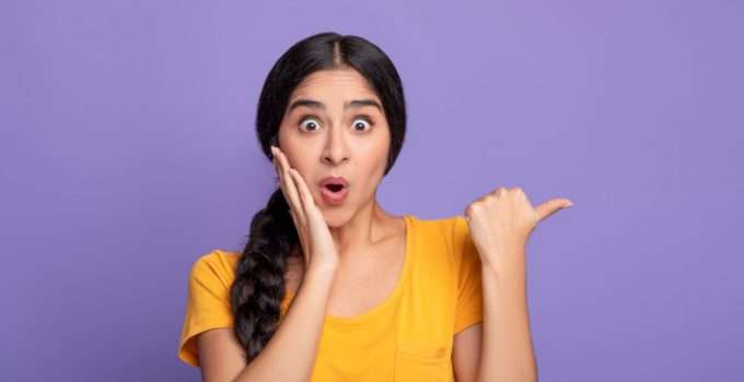 mujer de cabello oscuro señala al costado