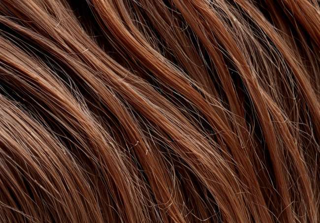 Vista en primer plano del cabello teñido que ha quedado con tonos rojizos luego del alisado