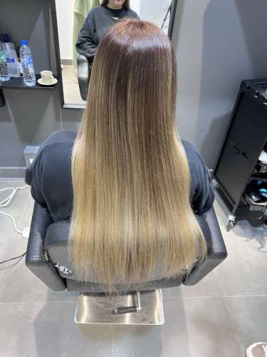 Vista desde atrás de una hermosa melena con balayage que después de 2 semanas se ha alisado