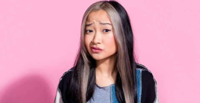 Una jovencita con gesto de duda acerca de si la keratina tumba el tinte